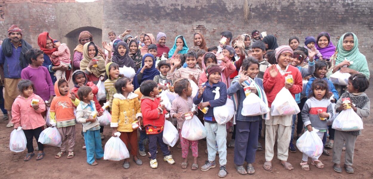 Bambini pakistani raggianti con i pacchi di Natale ricevuti da CSI. csi