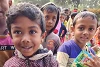 Bambini del Bangladesh dal volto felice con in mano ciascuno un pacchetto. csi